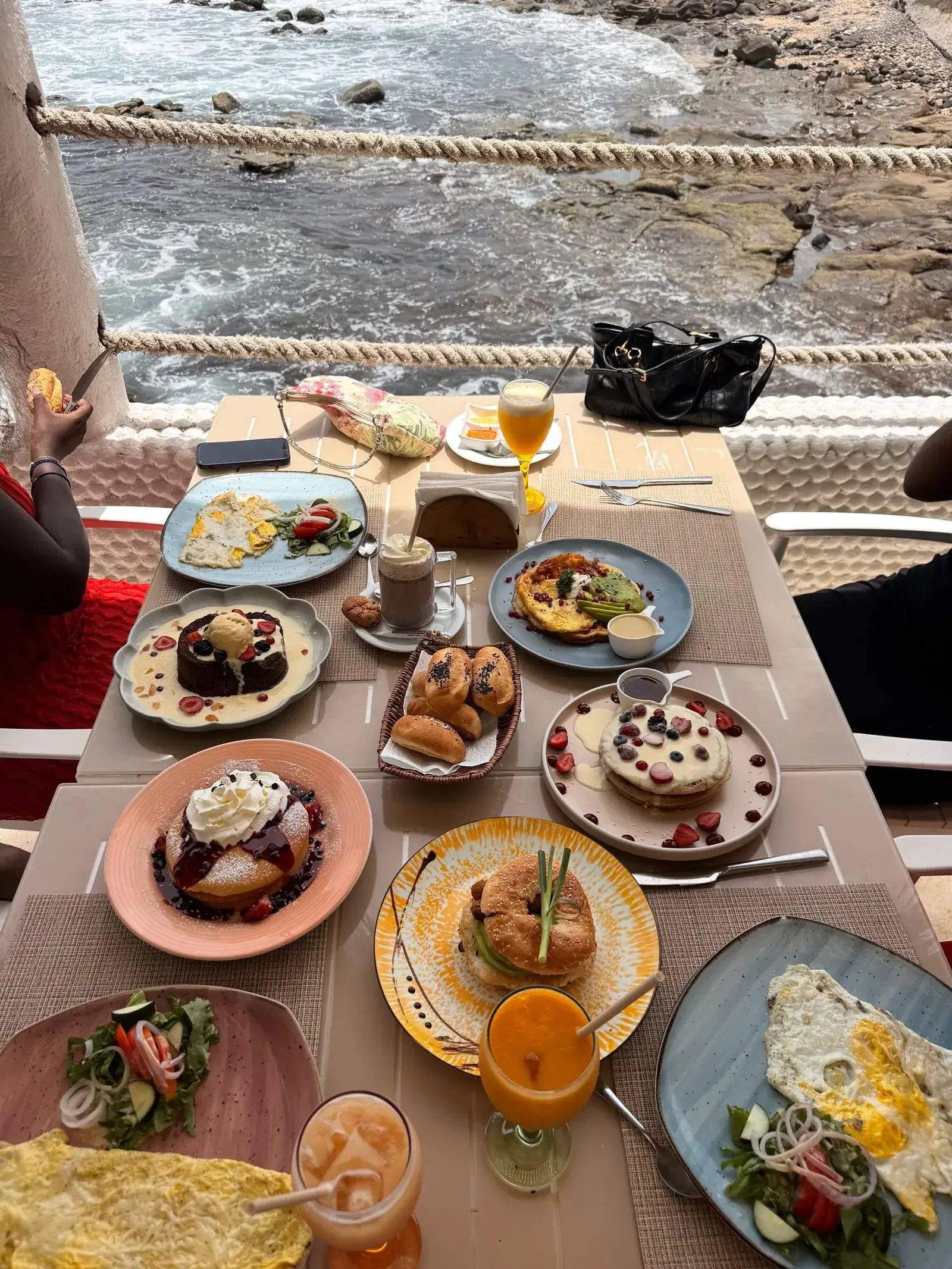 La table du brunch dressée face aux rochers, au Jet Café Beach