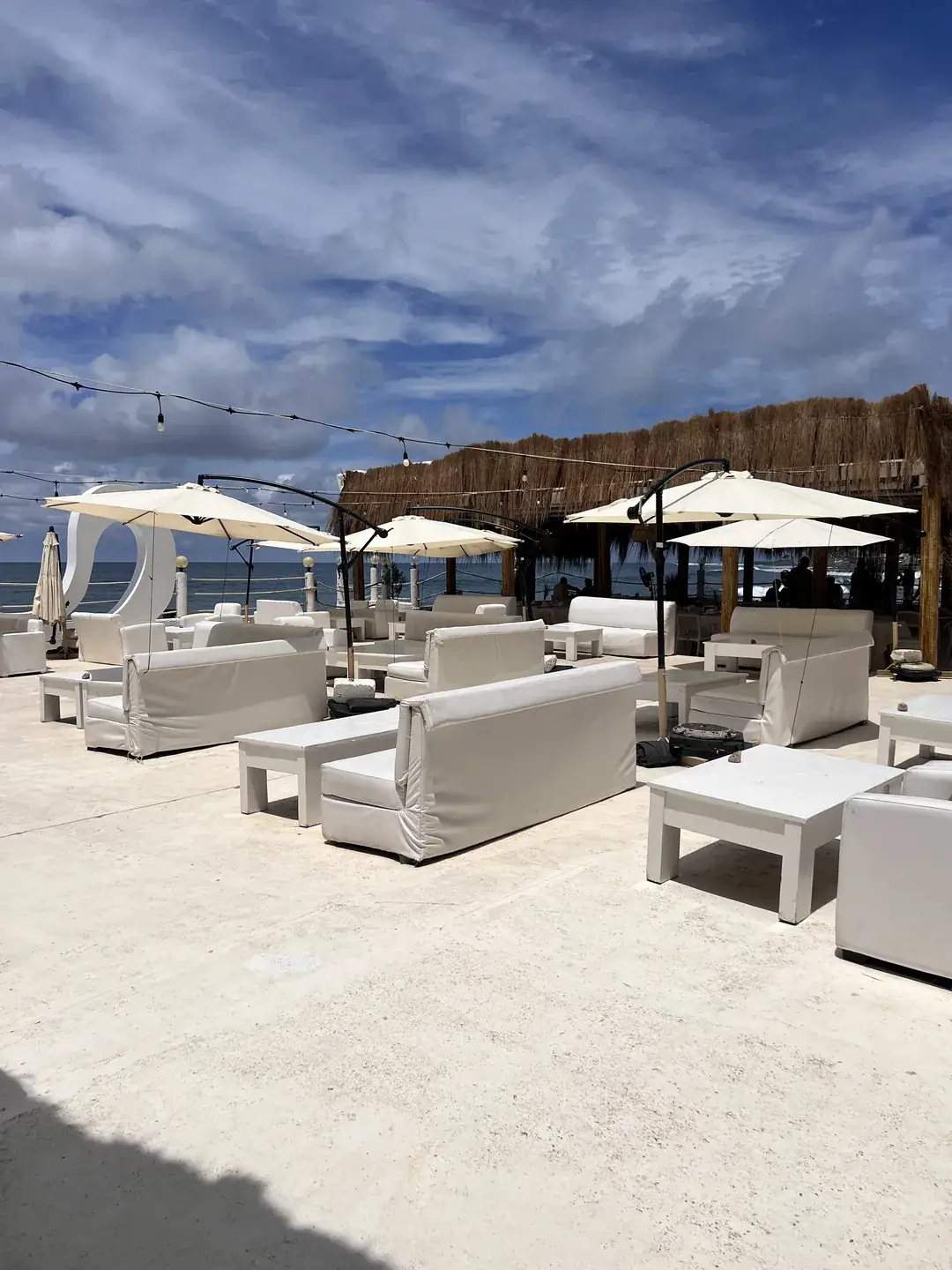 Le lounge du rooftop, banquettes blanches sous les parasols